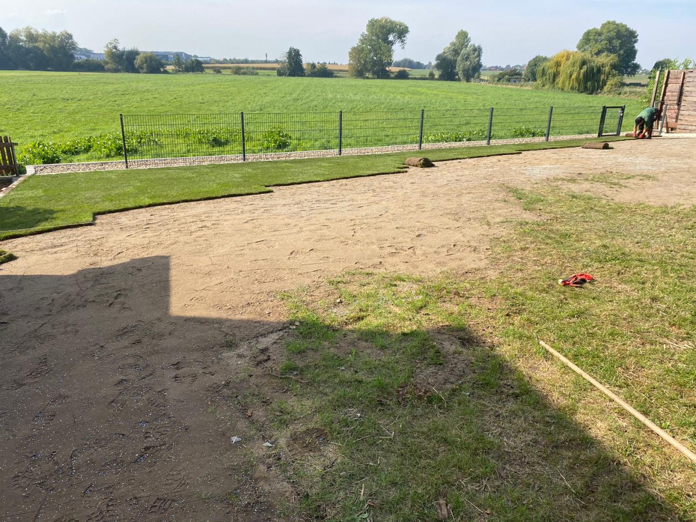 Fläche verfüllt und verdichtet. Zaun gesetzt, Rollrasen verlegt